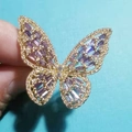 Detailed close-up of a golden butterfly ring with purple gems and sparkling crystals - Purple + 14K Gold