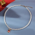 Collier de perles de Noël avec pendentif cloche rouge et nœud sur fond bleu texturé - Cloche de Noël / Blanc/Rouge