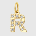 Macro detail of gold-plated letter R pendant encrusted with sparkling zircon stones - Letter R