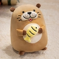 Cute brown plush sea otter toy holding a yellow fish doll on a warm cream rug - Medium / Brown