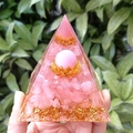 Pink crystal gravel orgone pyramid with gold leaf on lotus base held in hand - 8cm / Pink Cat's Eye Rose Quartz