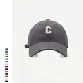 Detalle de gorra de béisbol gris oscuro con parche de letra C y textura de lona - Ajustable / Gris