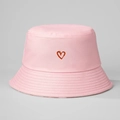 Close-up of pink cotton bucket hat featuring red embroidered heart detail and fine fabric texture - M (56-58cm) / Pink
