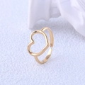 Vista macro di un anello a cuore dorato minimalista che mostra la texture liscia del metallo - Aperto Regolabile / Oro