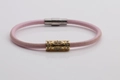 Dettaglio del bracciale in pelle rosa con ciondolo in cristallo dorato e chiusura magnetica - Rosa