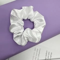Elegant white satin scrunchie with silky sheen on purple decorative column - White