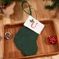 Green knit Christmas stocking with embroidered red letter U and festive pine cone decor - Letter U