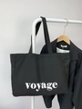 Minimalist black canvas tote bag with white voyage print hanging on a clothing rack - Large Capacity Letter Style / Voyage Black