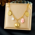 Detalle de collar dorado con colgantes de sol, luna y corazón rosa en joyero - Collar con Colgante de Corazón de Sol(N3741)