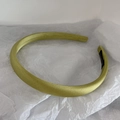 Detail of light yellow-green satin headband on white crinkled paper background - Yellow & Green