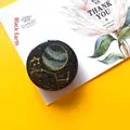 Top view of Black Earth planet phone socket with constellations on yellow background - Expanding Stand / Black Earth
