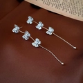 Detail of silver bow tassel earrings with sparkling cubic zirconia on brown fabric - 925 Silver Earring Post / Butterfly Tassel Earrings / Silver