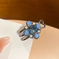 Close-up of floral hair clip with blue gemstones and hollow heart metal detailing - Hair Claw / Deep Blue Gem (Gun Black Base)