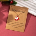 Dettaglio della collana con ciondolo Babbo Natale dorato su biglietto Merry Christmas - Babbo Natale Corpo Intero