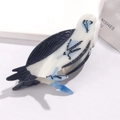 Detail of bird-shaped acetate hair claw clip featuring black and translucent white body - Bald Eagle