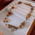 Close-up of vintage floral ceramic beaded necklace with butterfly charms in jewelry box - Multi-layer Retro/Amber
