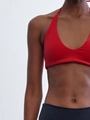 Close-up of a red halter neck yoga top with black bottoms on a model's torso - L -80 / Red