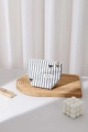 Dettaglio di una trousse trapuntata a righe con fiocchi neri su vassoio di legno - Piccolo / Righe Nere