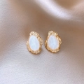 Macro view of gold irregular stud earrings with white pearlescent resin on silk - White-Waterdrop