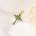 Pendente croce dorata vintage con pietre di zirconia verdi su sfondo di tessuto bianco - Verde
