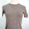 Elegant gold Y-shaped long necklace with white freshwater pearls on a grey sweater - Gold
