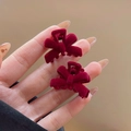 Pair of mini wine red velvet bow hair clips shown on hand for size perspective - Flocked Bow Small Hair Claw / Burgundy