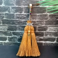 Close-up of Wiccan altar broom with triple moon symbol and chakra beads on dark wall - White Turquoise + Triple Moon + Crow Head