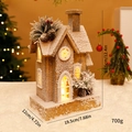 Verlicht houten kersthuis met kunstsneeuw en rode bessen in een warme feestelijke setting - Stereo Houten Huis Stijl B