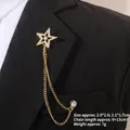 Détail d'une broche étoile avec chaînes et cristaux sur le revers d'un costume noir - Style Pentagramme Doré Évidé (TL24029)