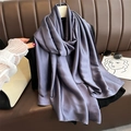 Detailed drape of purple-grey satin silk scarf hanging on a hanger over a leather couch - Dark Purple