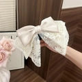 Detail of cream lace bow hair claw clip featuring elegant silk and embroidery texture - Lace Bow Ponytail Clip / Beige