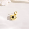 Gros plan d'un pendentif cœur 3D plaqué or 18k avec pierre de zircon noir et bélière - Cœur en or / Zircon Noir
