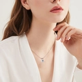 Elegant classic silver necklace with a 3-claw round moissanite pendant on a female model - 8mm / White