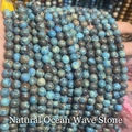 Close-up of hand holding natural sea wave stone round beads for DIY jewelry making - Natural Sea Wave Stone 4mm (Approx. 90pcs) Strand