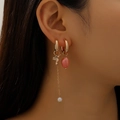 Close-up of asymmetrical earrings featuring golden bird, pearl chain and pink bead charm - KC Gold Bird Long Chain Style (10680)