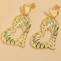 Detailed macro view of gold heart drop earrings featuring textured striped metal patterns - Heart Style
