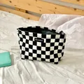 Große schwarz-weiße Kosmetiktasche mit Karomuster und Reißverschluss auf weißem Bett - Clutch Bag / Schwarz-Weißes Schachbrett