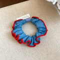 Close-up of blue denim scrunchie with red stitching detail on a canvas background - Solid Denim Red Edge Style / Light Blue