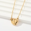 Close-up of interlocking heart pendants in gold finish with crystal inlay and fine chain - Heart Zirconia