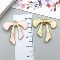 Pink enamel and gold bow pendant charms with size reference on ruler measuring 3x3.5 cm - KC Gold Pink Bowknot