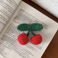 Macro view of handmade crochet red cherries with green leaves on an open book - Duckbill Hair Clips / Cherry Hair Clip (Red/Green)