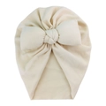 Detail of soft knit baby turban hat in beige featuring a large decorative plush bow - Beige