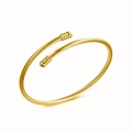 Dettaglio macro del bracciale rigido a fune dorata con finiture sferiche e design aperto - Oro
