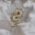 Broche dragon dorée élégante avec écailles détaillées sur un fond de satin soyeux - Dragon Enroulé Or Mat (5109284685239)