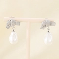Detail of silver bow earrings with baroque pearl drops on a minimalist jewelry stand - Steel Rope Knot (KE116092-GC)