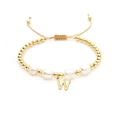 Detail of adjustable woven bracelet featuring baroque pearls and gold letter W charm - Letter W
