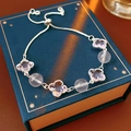 Detail of beaded bracelet with pink crystals and purple clover charms on a gift box - Lychee Pink (Pink)