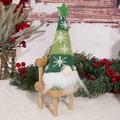 Dettaglio di uno gnomo natalizio con cappello verde in maglia su mini sedia in legno - Uomo della Foresta Seduto / Verde