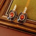 Macro detail of vintage enamel earrings with orange gems and rhinestones on wood backdrop - 50# Silver Pin Enamel Rhinestone Oval Variant