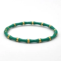 Detailed macro view of green enamel bamboo style bracelet with golden metal joints - Green